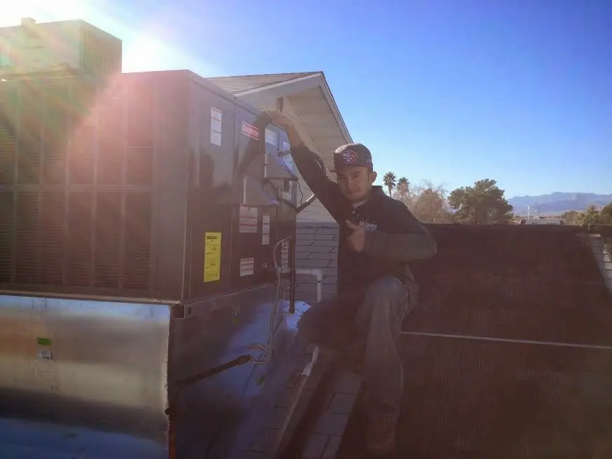 HVAC technician performing AC Tune-Up on a rooftop unit in Godfrey